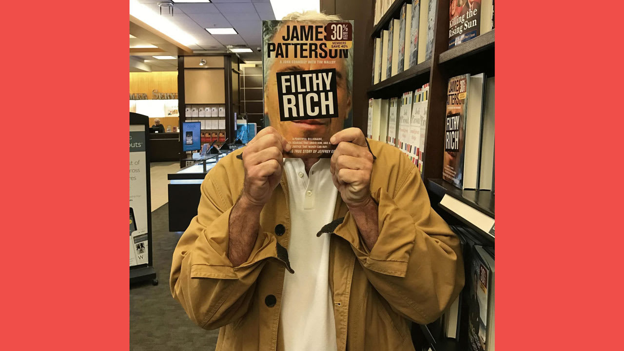 يظهر رجل يبدو أنه إبستين وهو يمسك بكتاب جيمس باترسون بعنوان