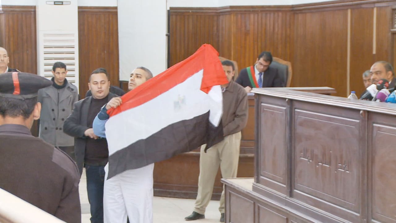 بالفيديو.. أحد صحفيي الجزيرة يرفع علم مصر أمام المحكمة