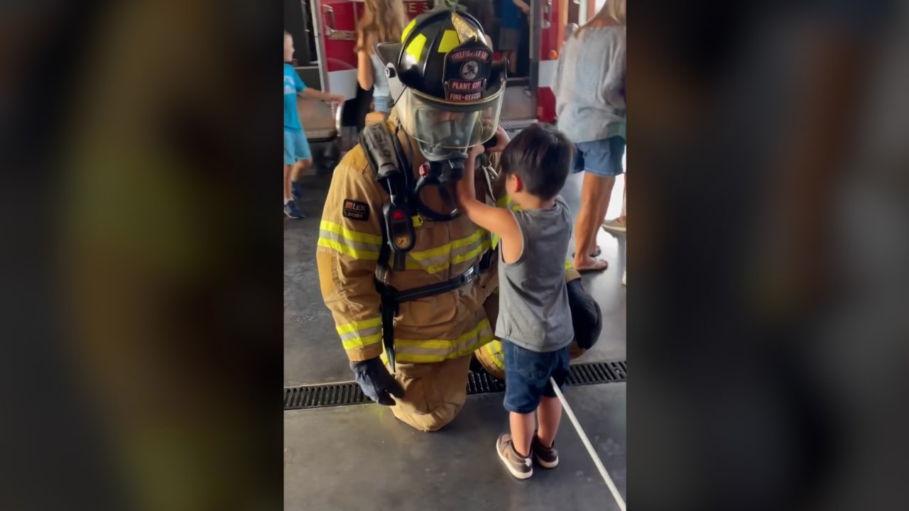 شاهد رد فعل طفل كفيف يرى لأول مرة من خلال تحسسه رجل إطفاء بمعداته بيديه