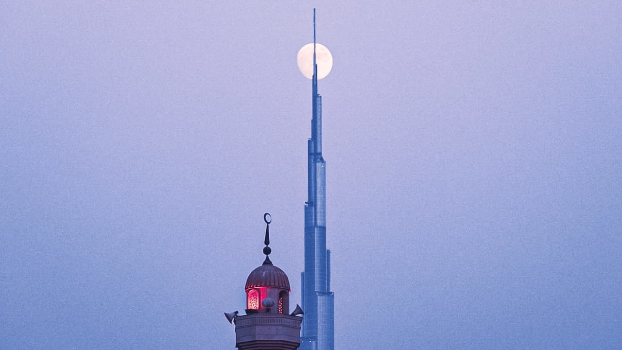 في دبي..شاهد القمر يلامس قمة أعلى برج في العالم