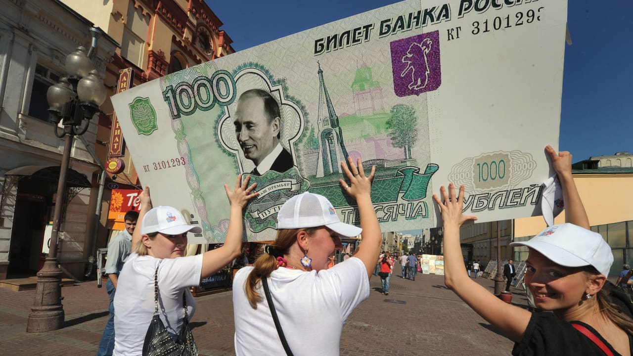 صورة أرشيفية لنشطاء يحملون العملةالروسية وقد وضع عليها صورة بوتين العام 2011