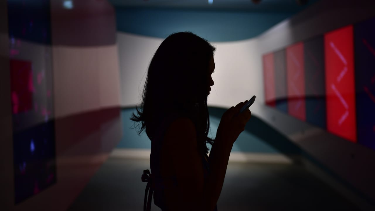 عارضة أزياء تكتب رسالة على هاتفها المحمول أثناء عرض أزياء