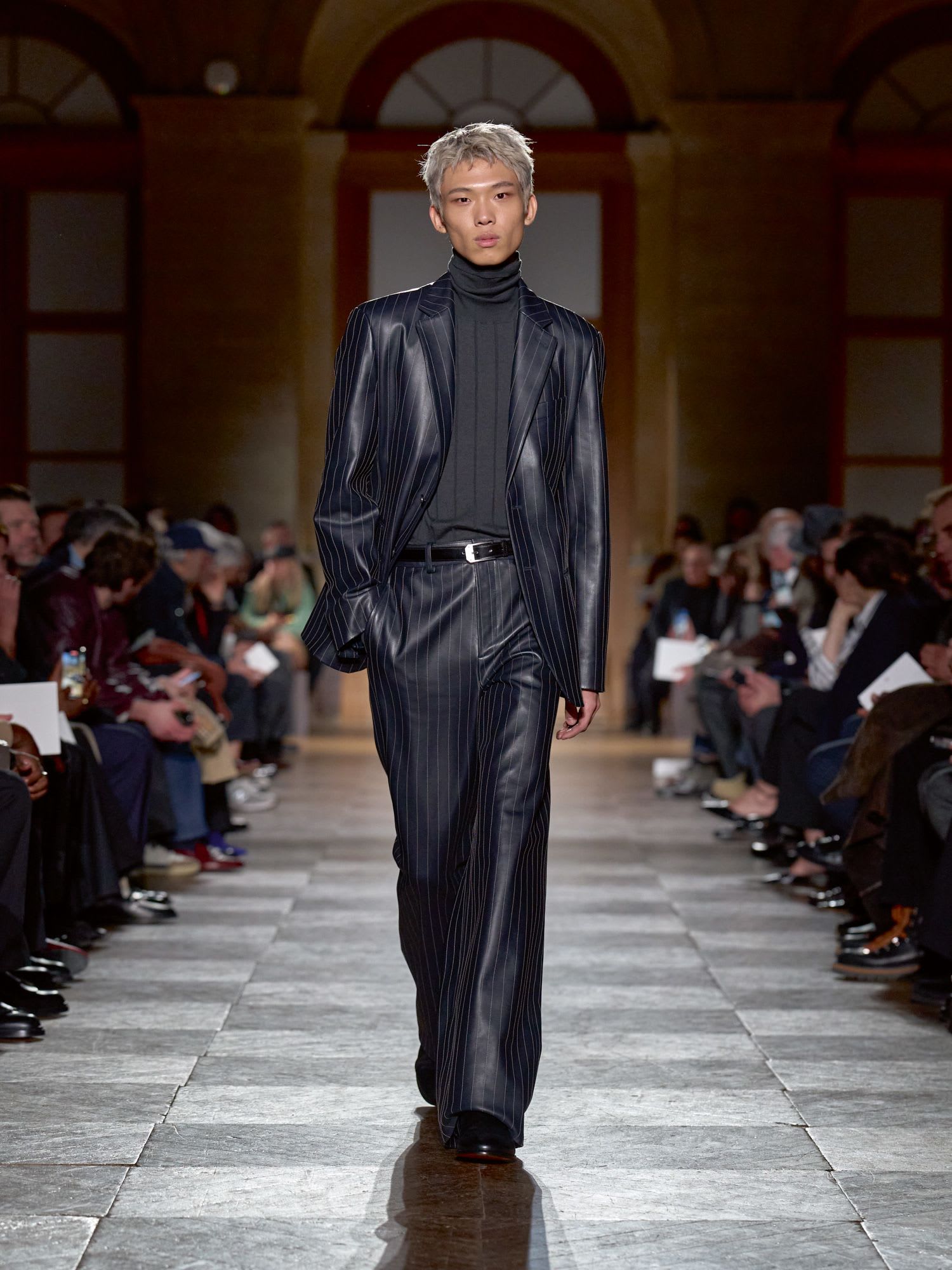 تضمن العرض العديد من القطع الجلدية المصممة بعناية فائقة، مثل هذه البدلة المخيطة بخطوط دقيقة تشبه الطباشير.