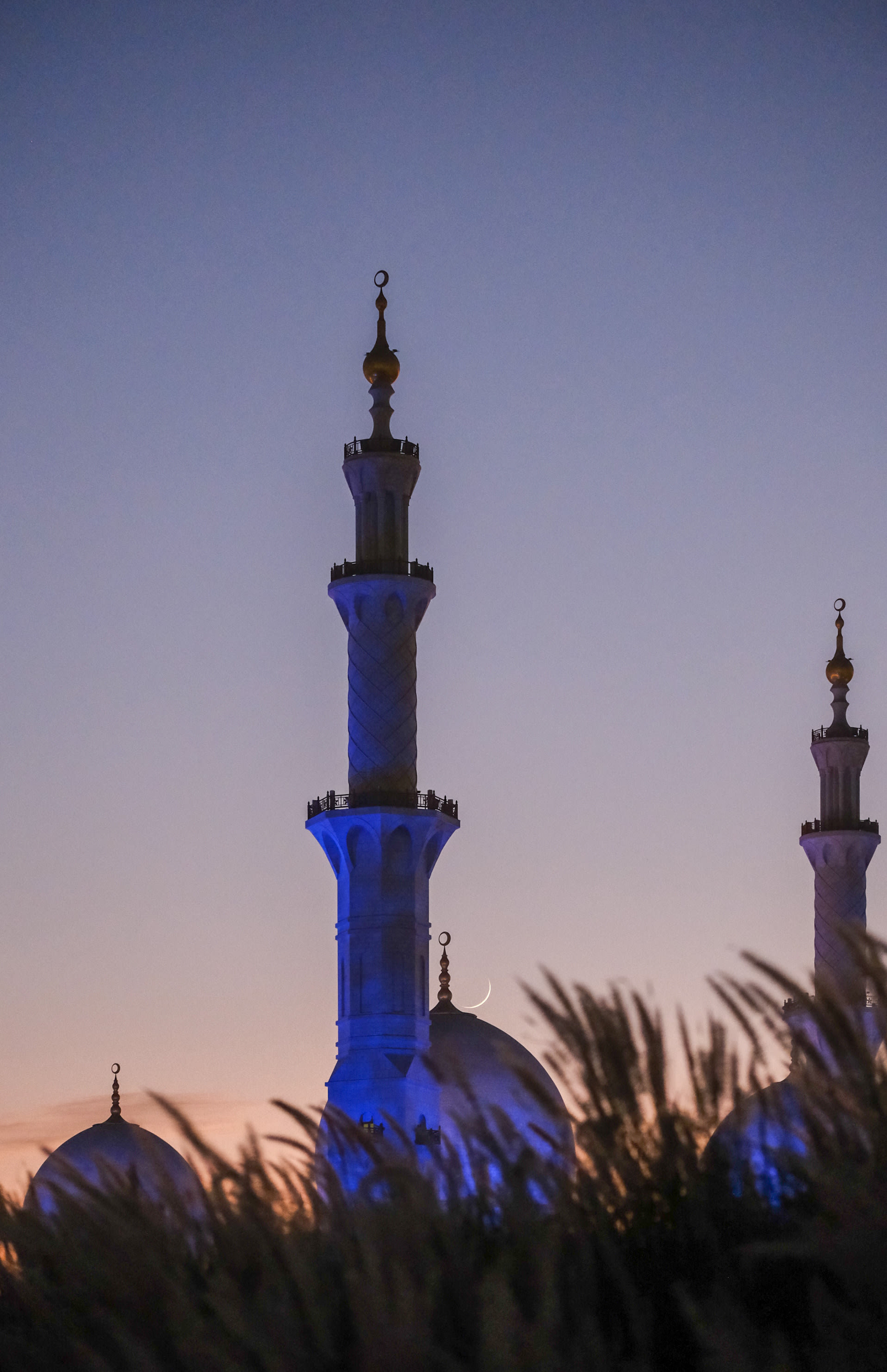 مصور يرصد القمر فوق مآذن المساجد في الإمارات بصور آسرة