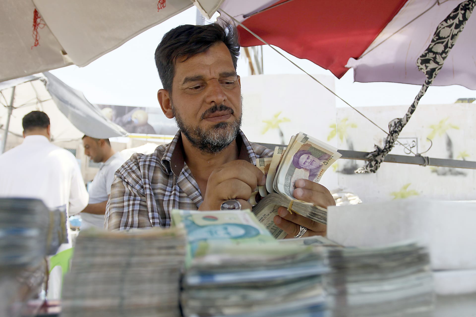 رجل يعد نقودا في إيران