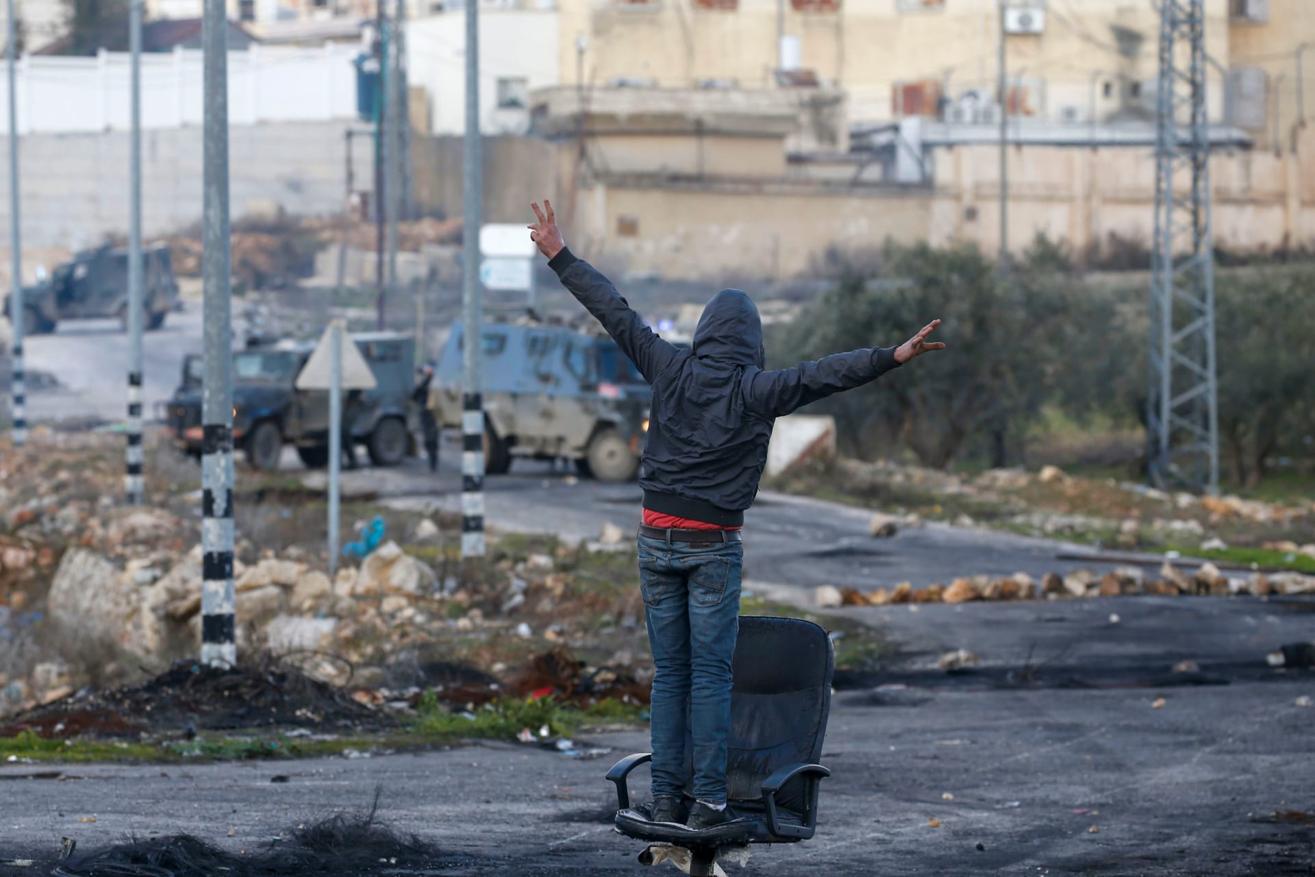 متظاهر فلسطيني مقابل قوات الأمن الإسرائيلية خلال الاشتباكات عقب مظاهرة احتجاج على اقتراح خطة سلام أمريكية