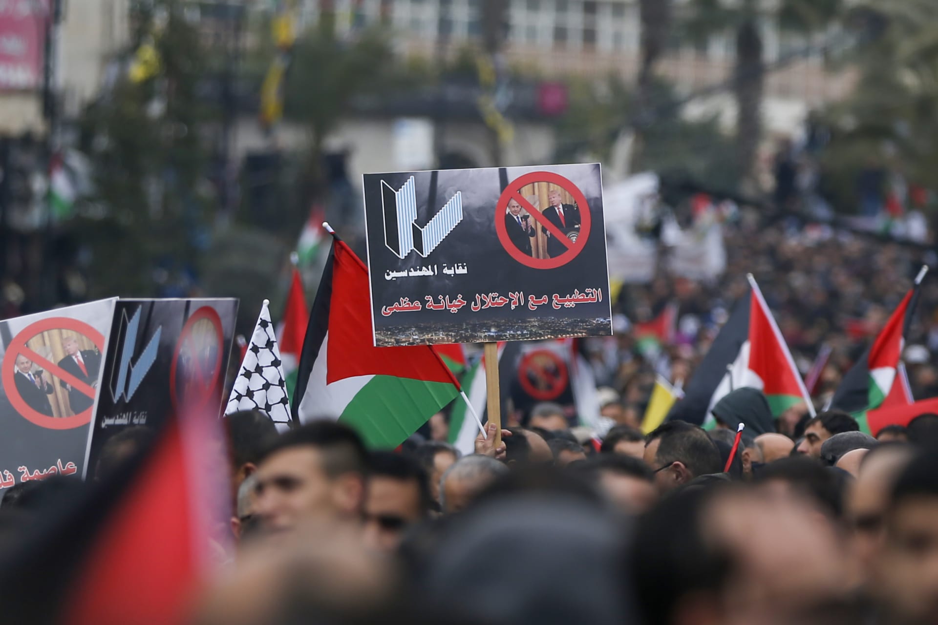متظاهر فلسطيني يحمل لافتة مناهضة لتطبيع العلاقات مع اسرائيل في مدينة رام الله بالضفة الغربية