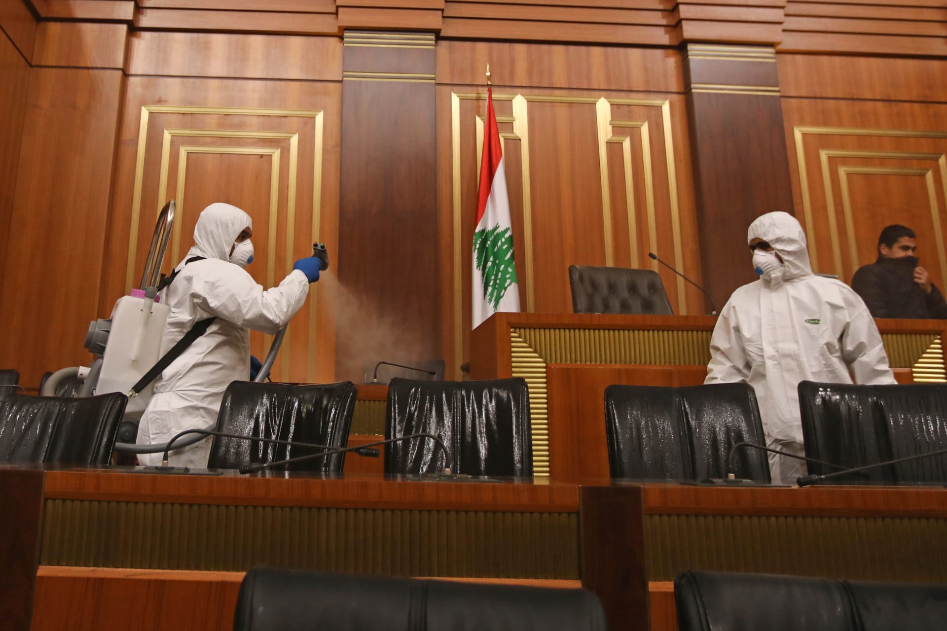 عمال يعملون على تعقيم البرلمان اللبناني بعد تفشي فيروس كورونا