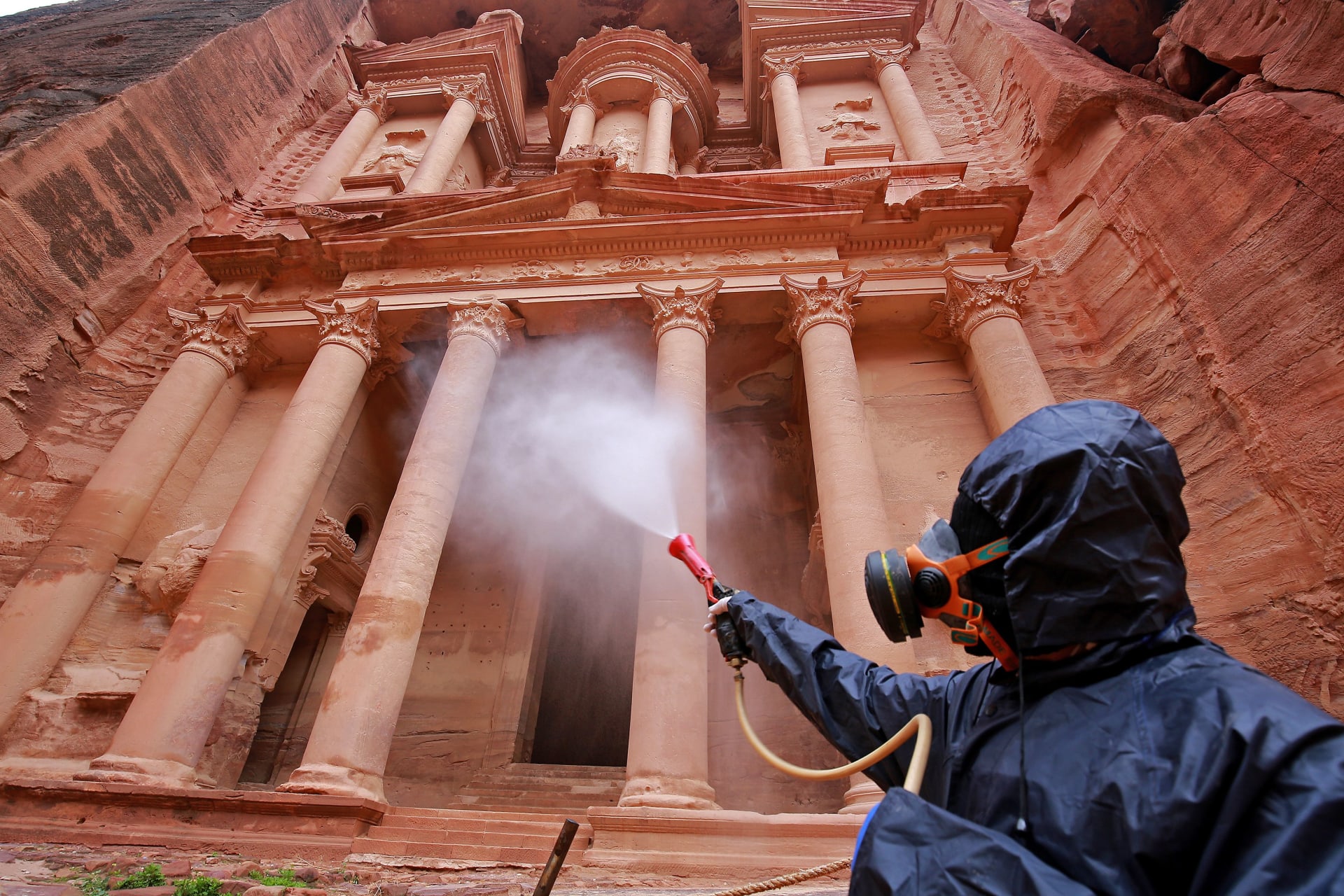 عامل يقوم بتعقيم موقع البتراء الأثري في الأردن بعد انتشار فيروس كورونا