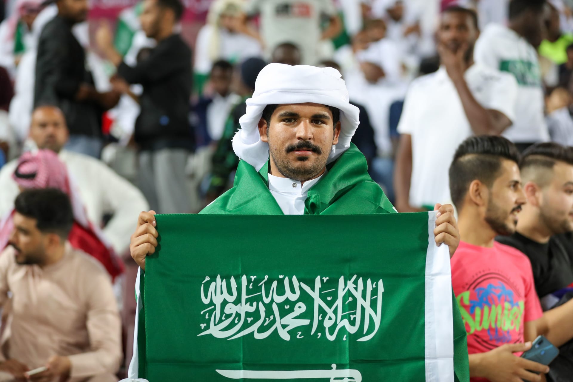 أحد مشجعي المنتخب السعودي لكرة القدم يرفع علم بلاده في منافسات بطولة الخليج الأخيرة