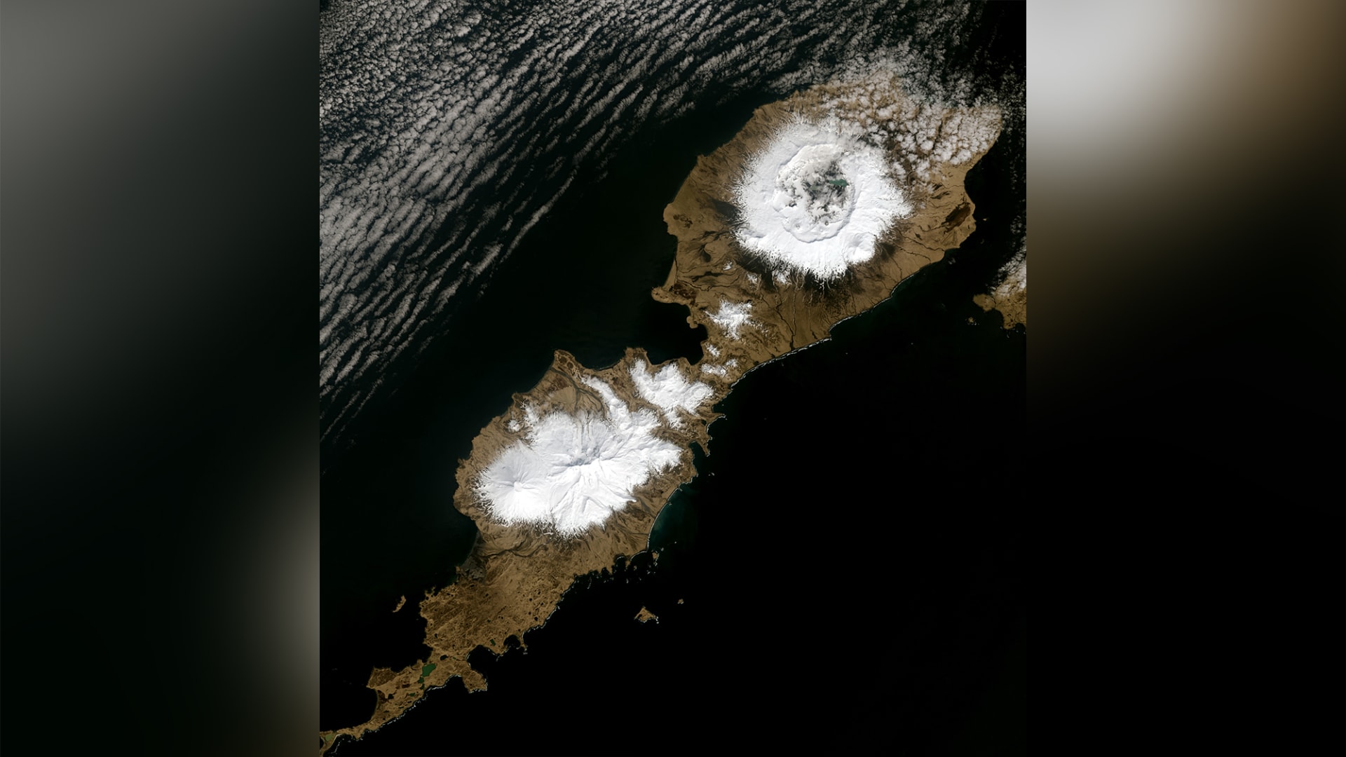 صورة تُظهر فوهة البركان (في أعلى اليمين) في جزيرة "أومناك" في ألاسكا.