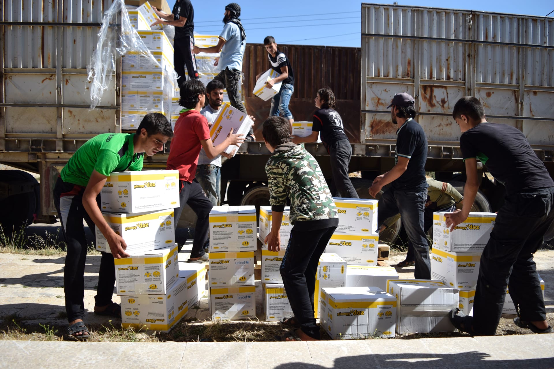 سوريون يحملون مساعدات إنسانية من برنامج الأغذية العالمي التابع للأمم المتحدة 