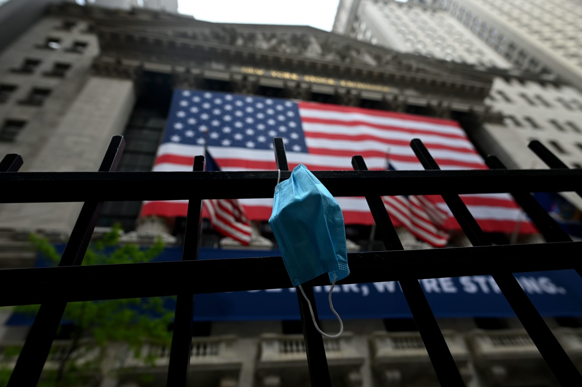 صورة تعبيرية تظهر كمامة معلقة أمام مبنى البورصة في نيويورك