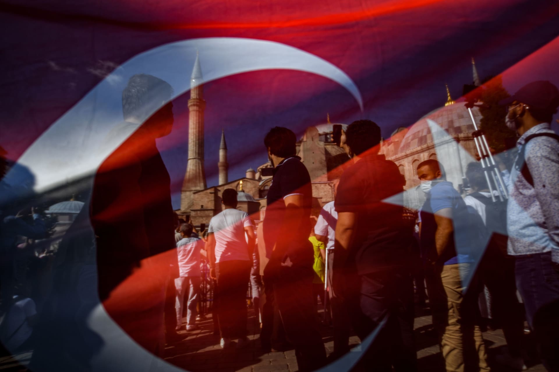 صورة عبر العلم التركي لأشخاص يتجمعون أمام مسجد آيا صوفيا بعد تحويله