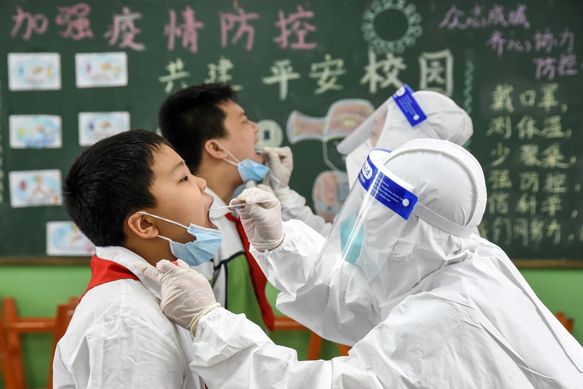فريق طبي يجري فحوصات للكشف عن فيروس كورونا بين عدد من طلاب المدارس في الصين