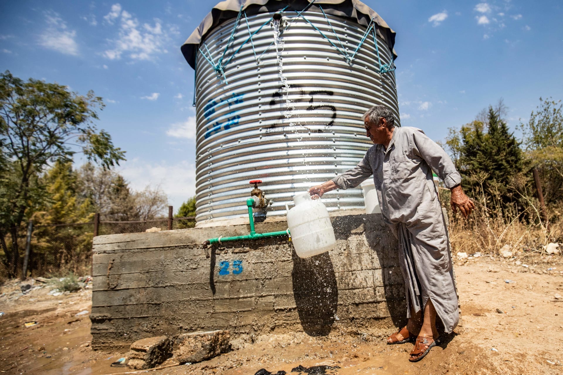 رجل يملأ ماء من خزان أعدته منظمات إنسانية في الحسكة بـ22 أغسطس 2020