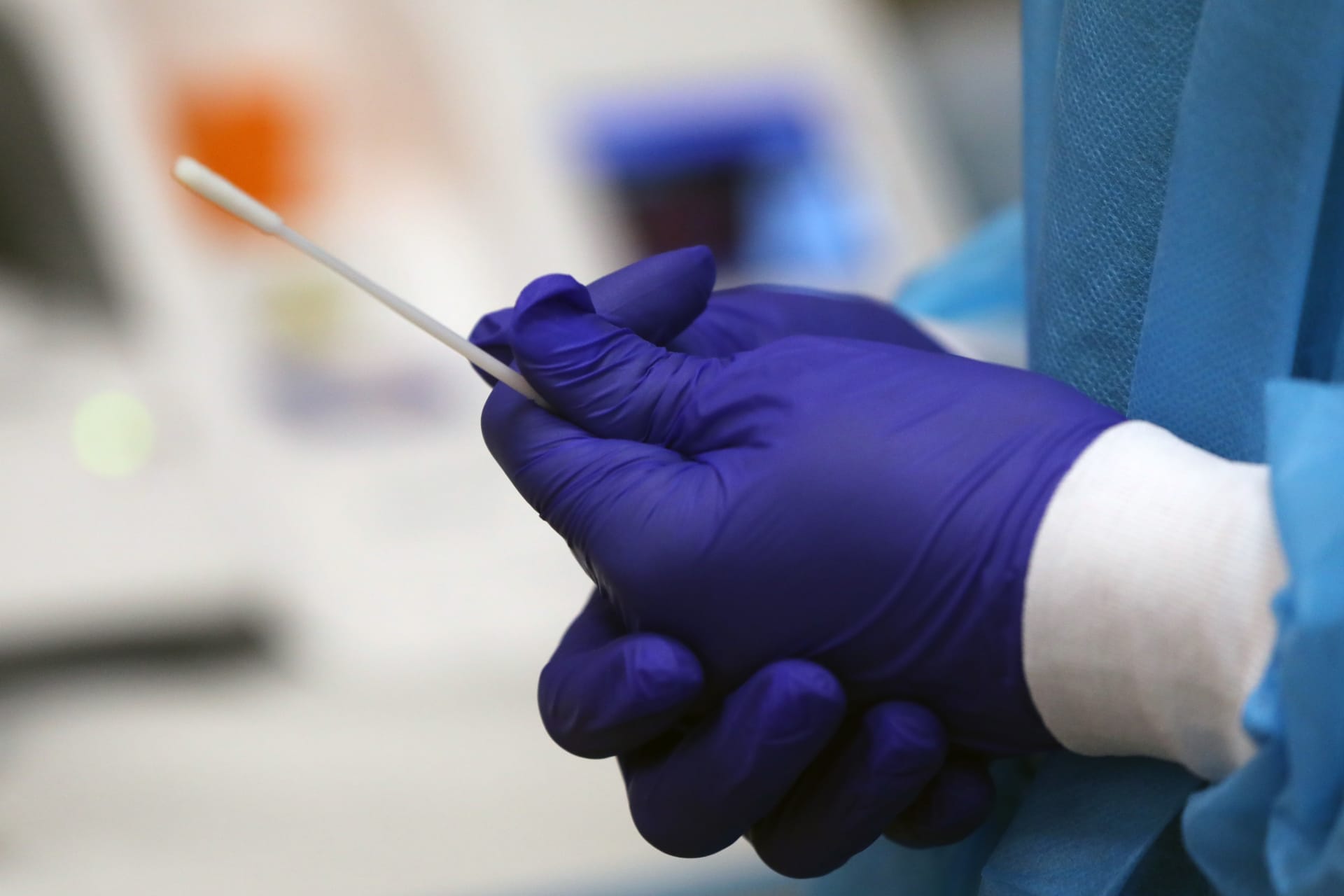عامل طبي يُظهر عملية اختبار فيروس كورونا المستجد