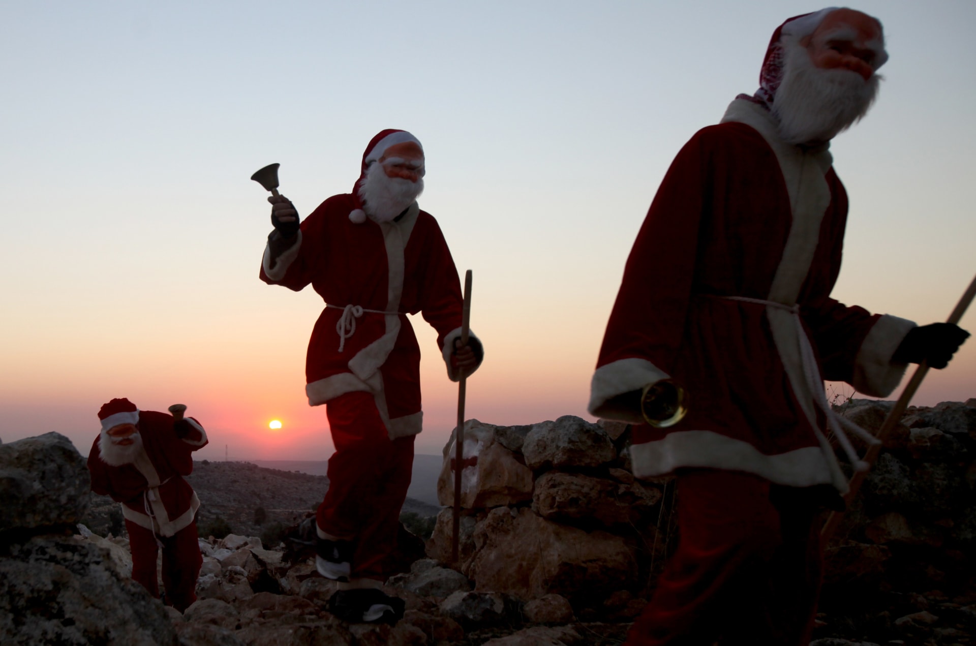 صورة ارشيفية (تعبيرية) لأشخاص يرتدون زي "بابا نويل" احتفالا بعيد الميلاد في قرى فلسطينية