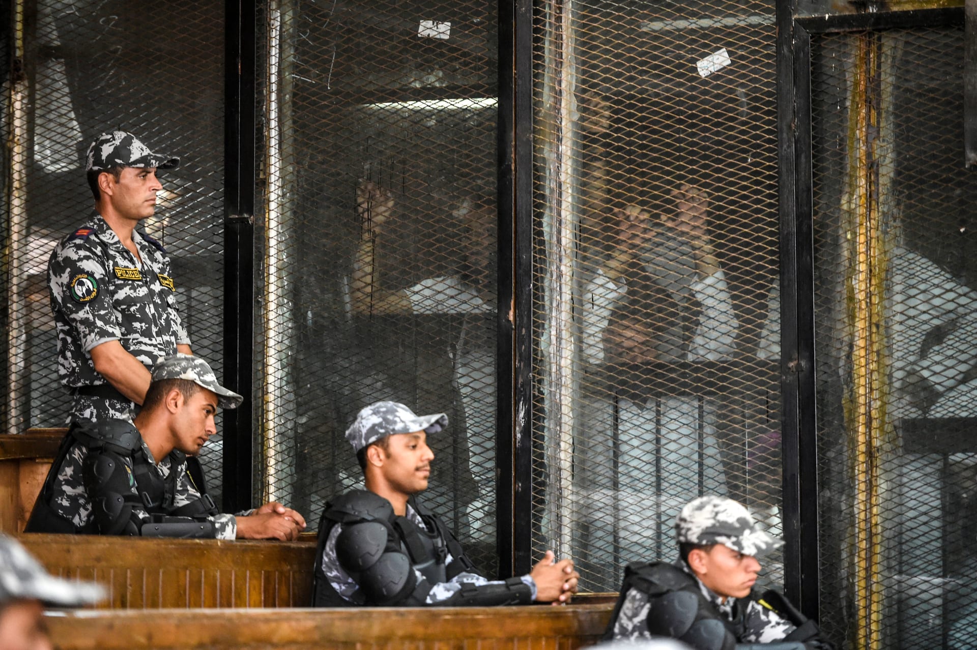 أعضاء من جماعة الإخوان المسلمين المحظورة في مصر يشاهدون داخل رصيف زجاجي أثناء محاكمتهم في العاصمة القاهرة في 28 يوليو 2018