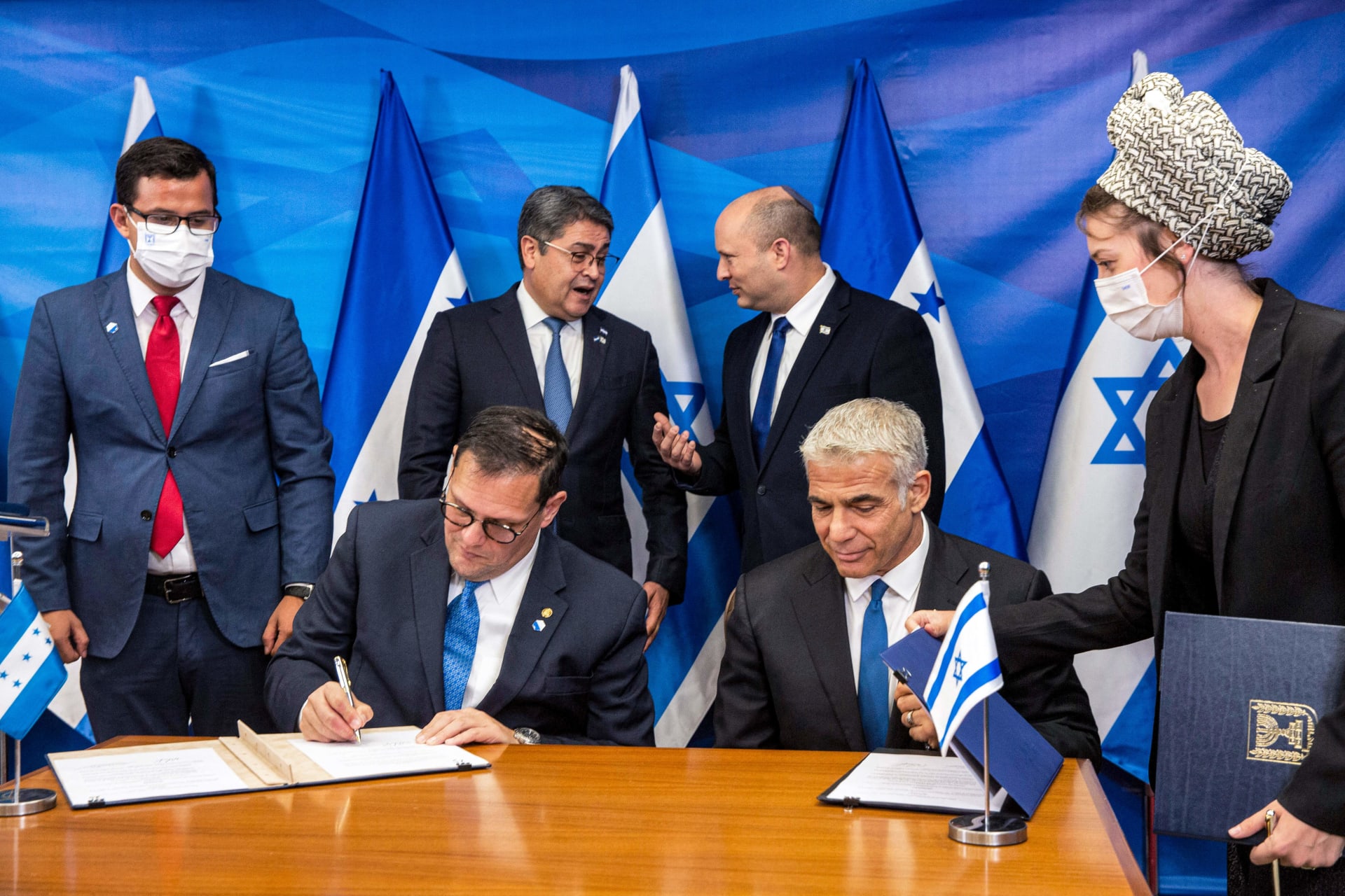 وزير الخارجية الإسرائيلي يائير لابيد (أسفل اليمين) ووزير خارجية هندوراس ليساندرو (أسفل اليسار) يوقعان اتفاقيات ثنائية في مكتب رئيس الوزراء في القدس يوم 24 يونيو 2021