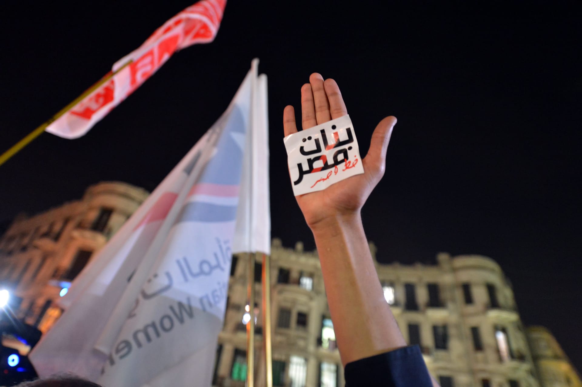 متظاهر مصري يرفع يده بشعار مكتوب بالعربية: "الفتيات المصريات خط أحمر" خلال مظاهرة في القاهرة ضد التحرش الجنسي في 12 فبراير 2013.