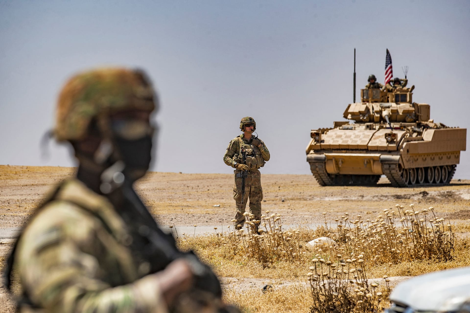 جندي أمريكي يقف بالقرب من مركبة برادلي القتالية خلال دورية بالقرب من آبار النفط في الرميلان في محافظة الحسكة شمال شرق سوريا، 22 يونيو 2021
