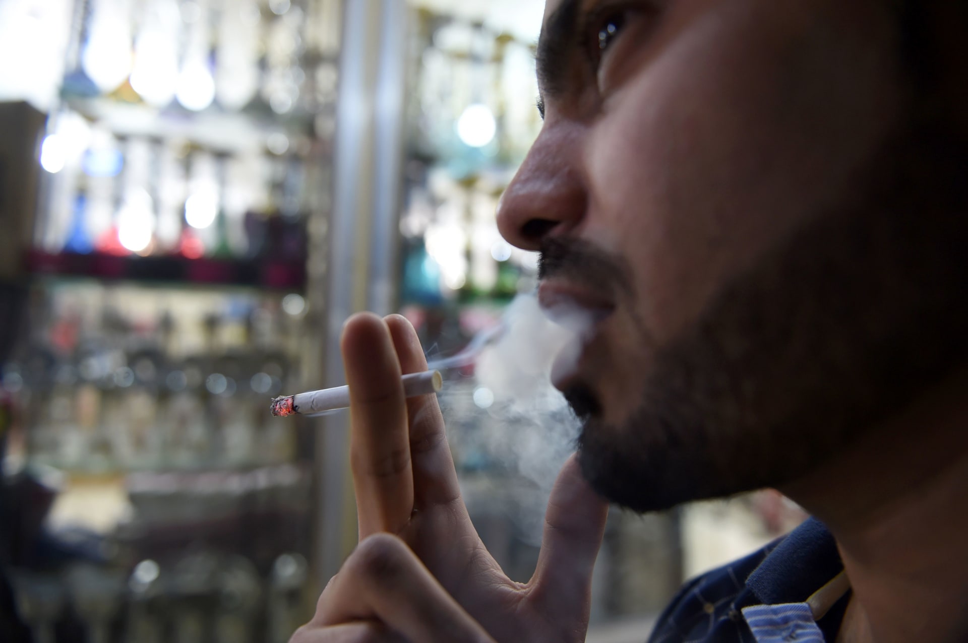 رجل يدخن خارج متجر لبيع التبغ في العاصمة السعودية الرياض في وقت متأخر من يوم 11 يونيو 2017.
