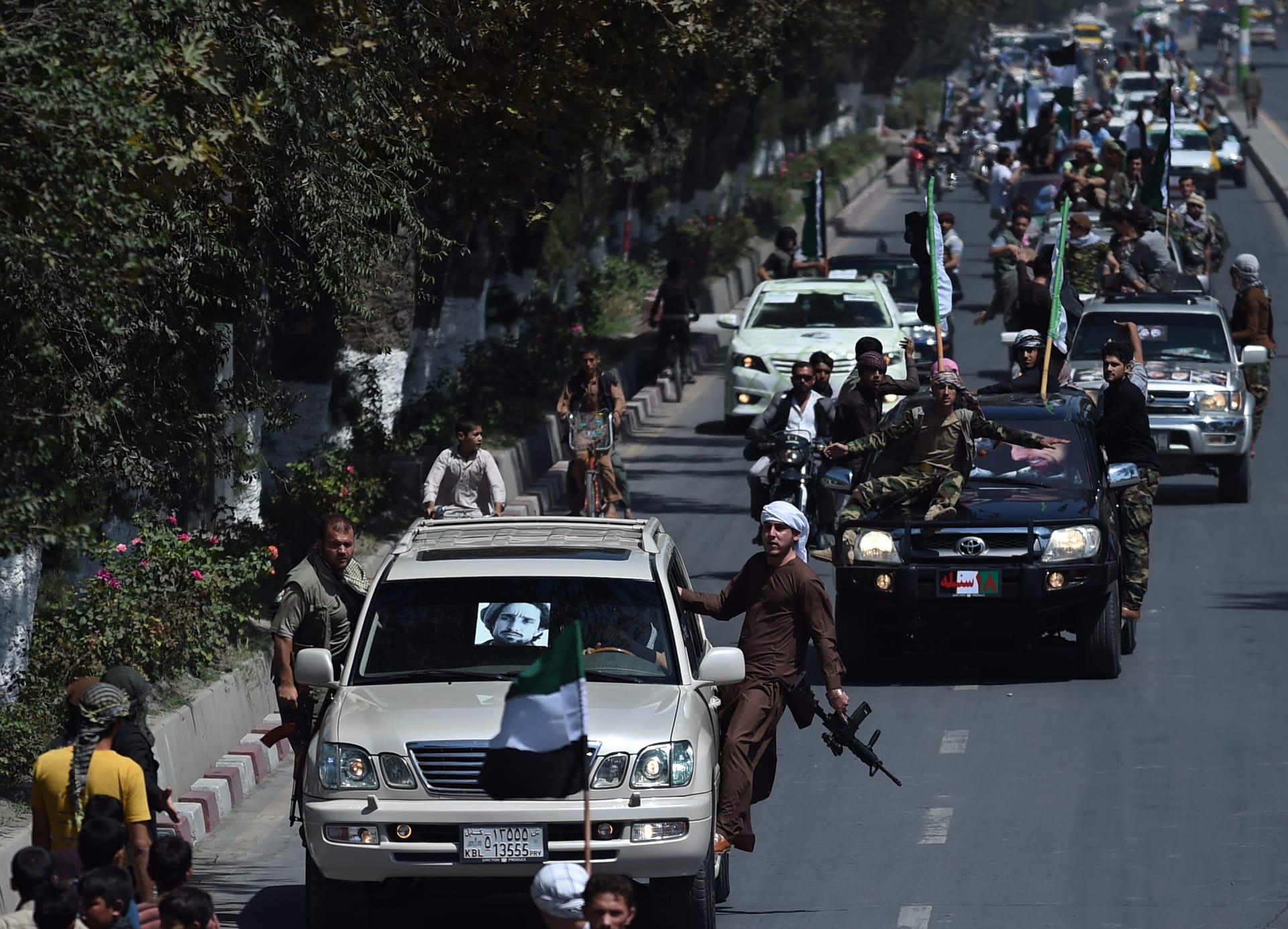 أنصار زعيم المقاومة الراحل أحمد شاه مسعود يحملون أسلحة أثناء ركوبهم في قافلة للاحتفال بالذكرى السنوية الرابعة عشرة لوفاته في كابول في 9 سبتمبر 2015