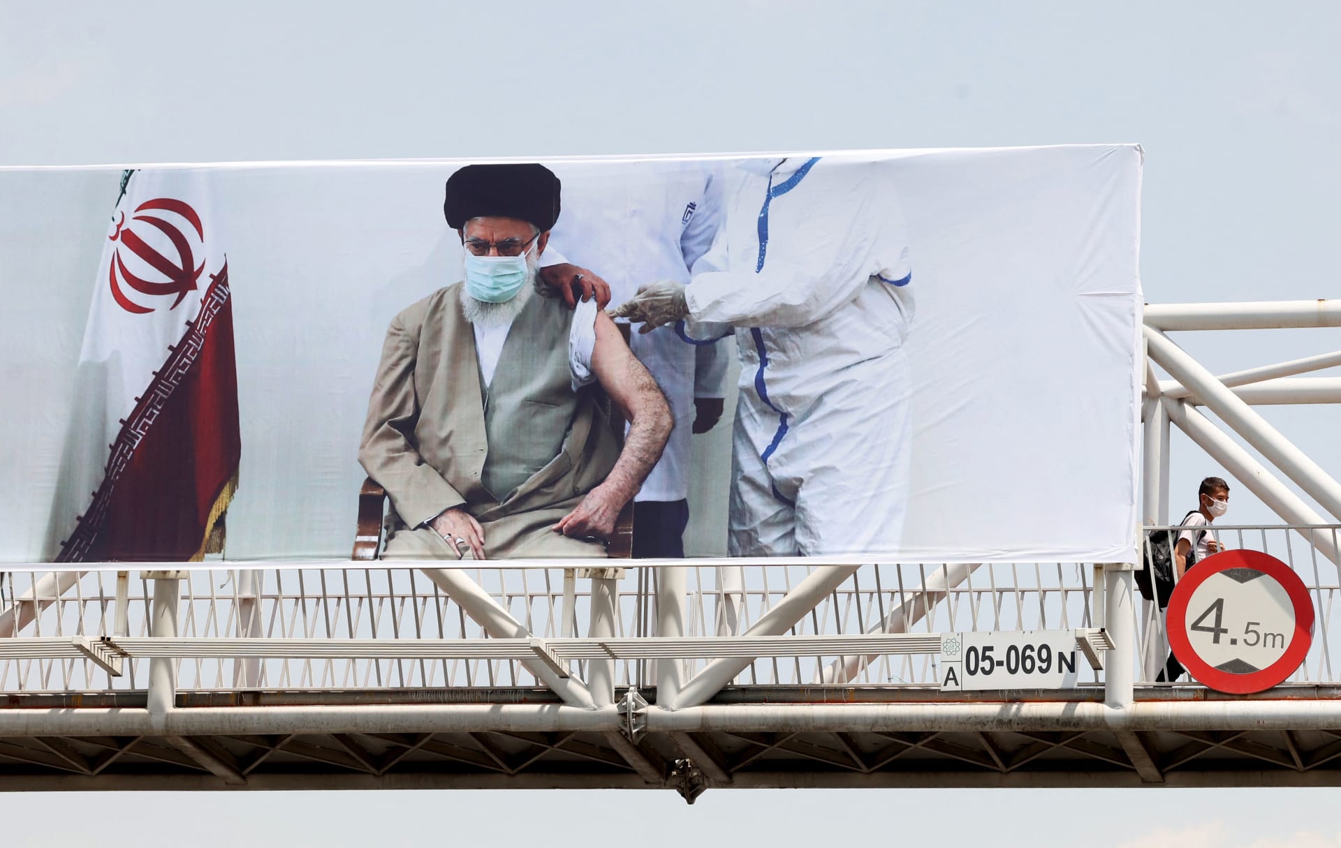  لافتة تظهر المرشد الإيراني علي خامنئي وهو يتلقى لقاحًا ضد فيروس كورونا، في العاصمة طهران - في 3 يوليو / تموز 2021. 