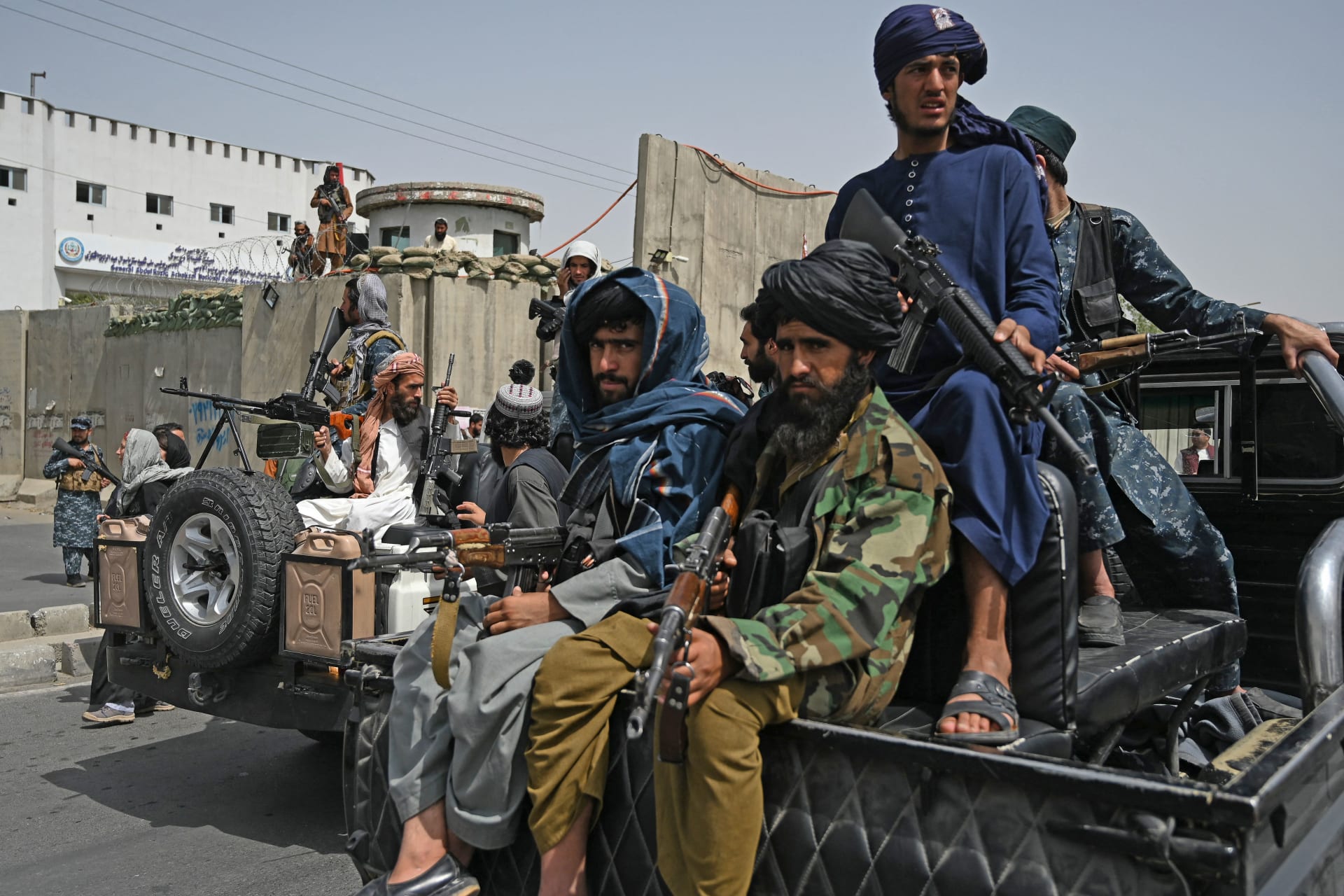 مقاتلو طالبان يرافقون نساء محجبات أثناء مسيرة مؤيدة لطالبان خارج جامعة الشهيد رباني في كابول - 11 سبتمبر 2021