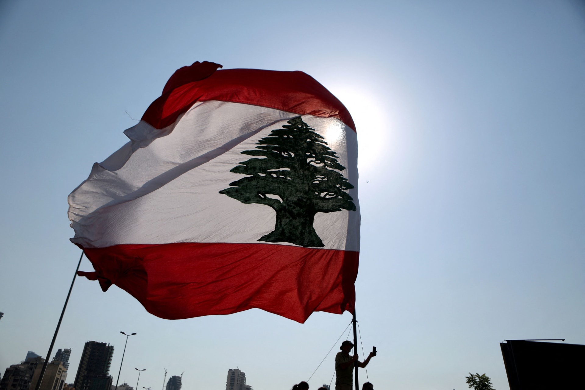 رفع العلم اللبناني خلال مراسم إحياء ذكرى في ميناء العاصمة اللبنانية بيروت في 4 أغسطس / آب 2021 ،