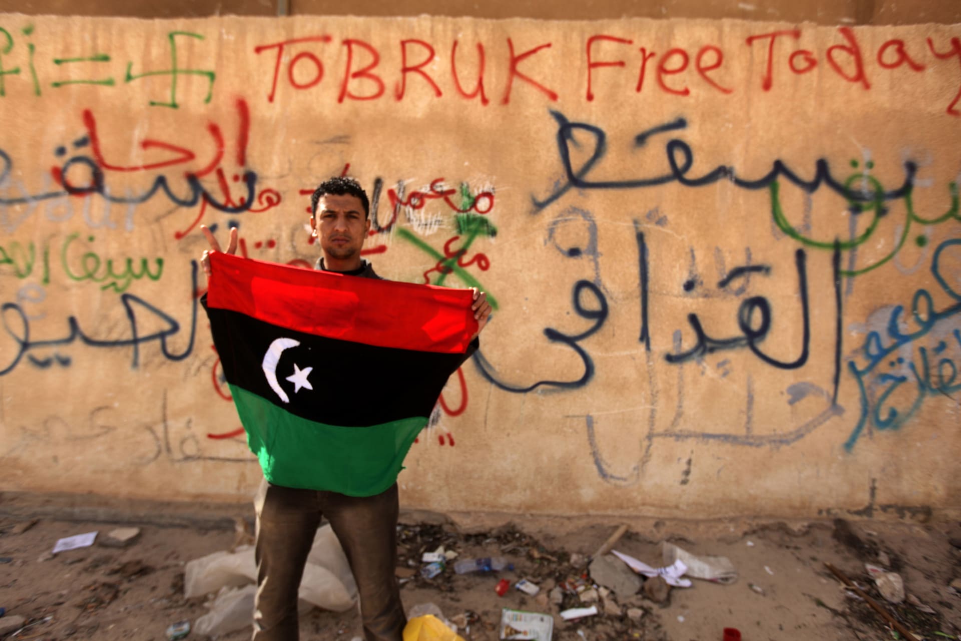 مواطن ليبي يرفع علم بلاده