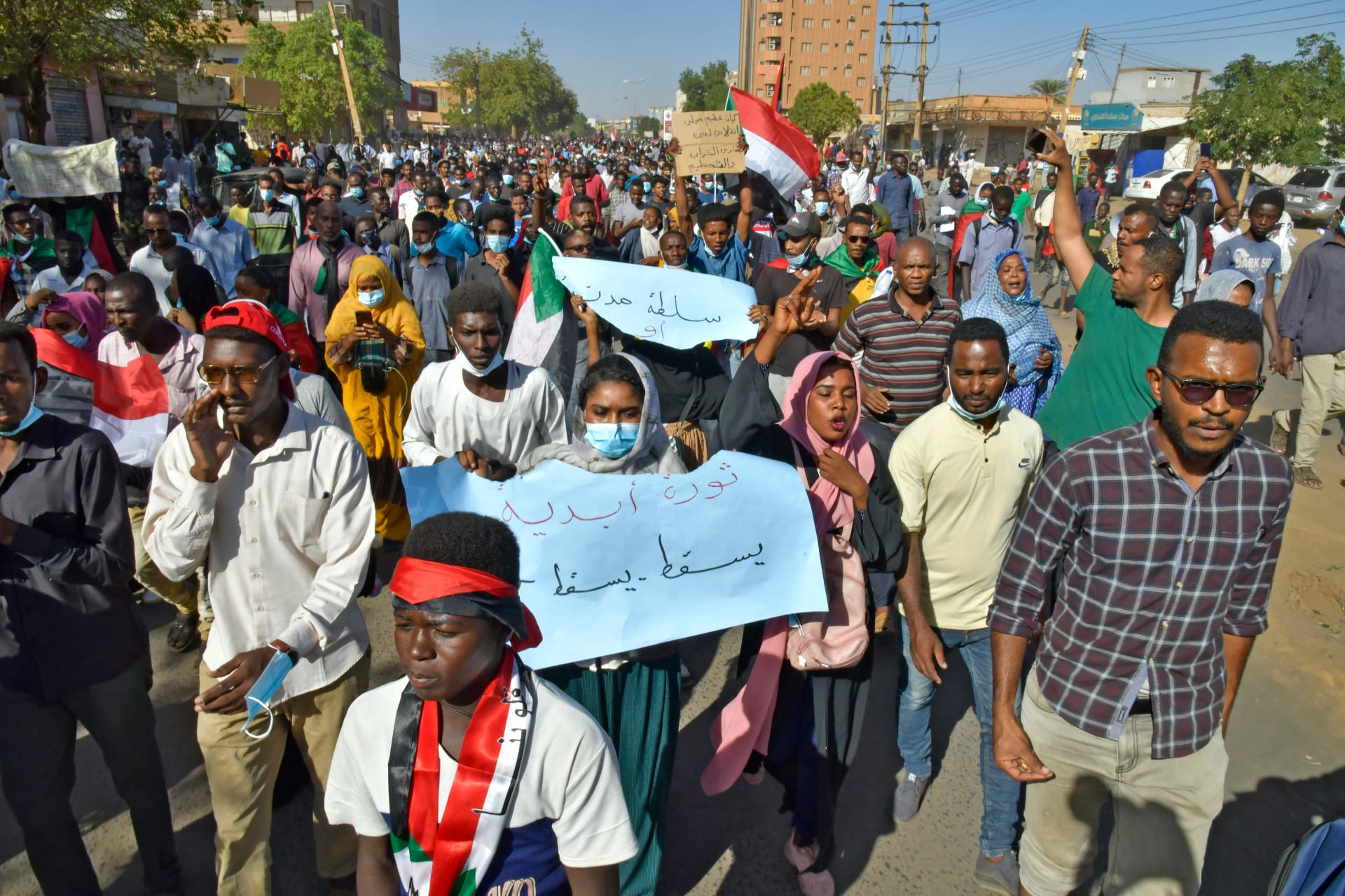 متظاهرون سودانيون يرفعون لافتات وأعلام خلال مظاهرة تطالب بعودة الحكم المدني في أم درمان