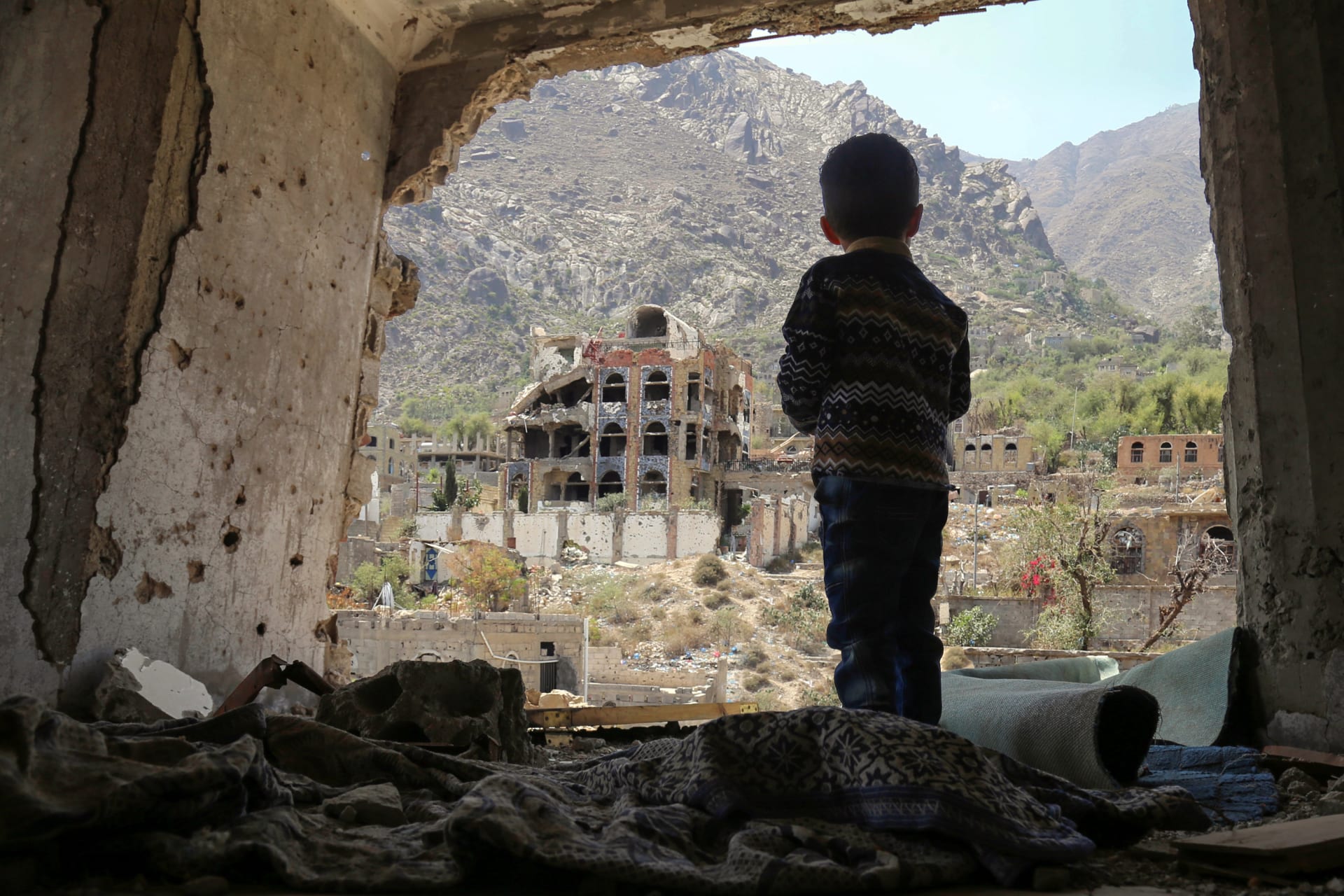طفل ينظر إلى المباني المهدمة في مدينة تعز اليمنية 
