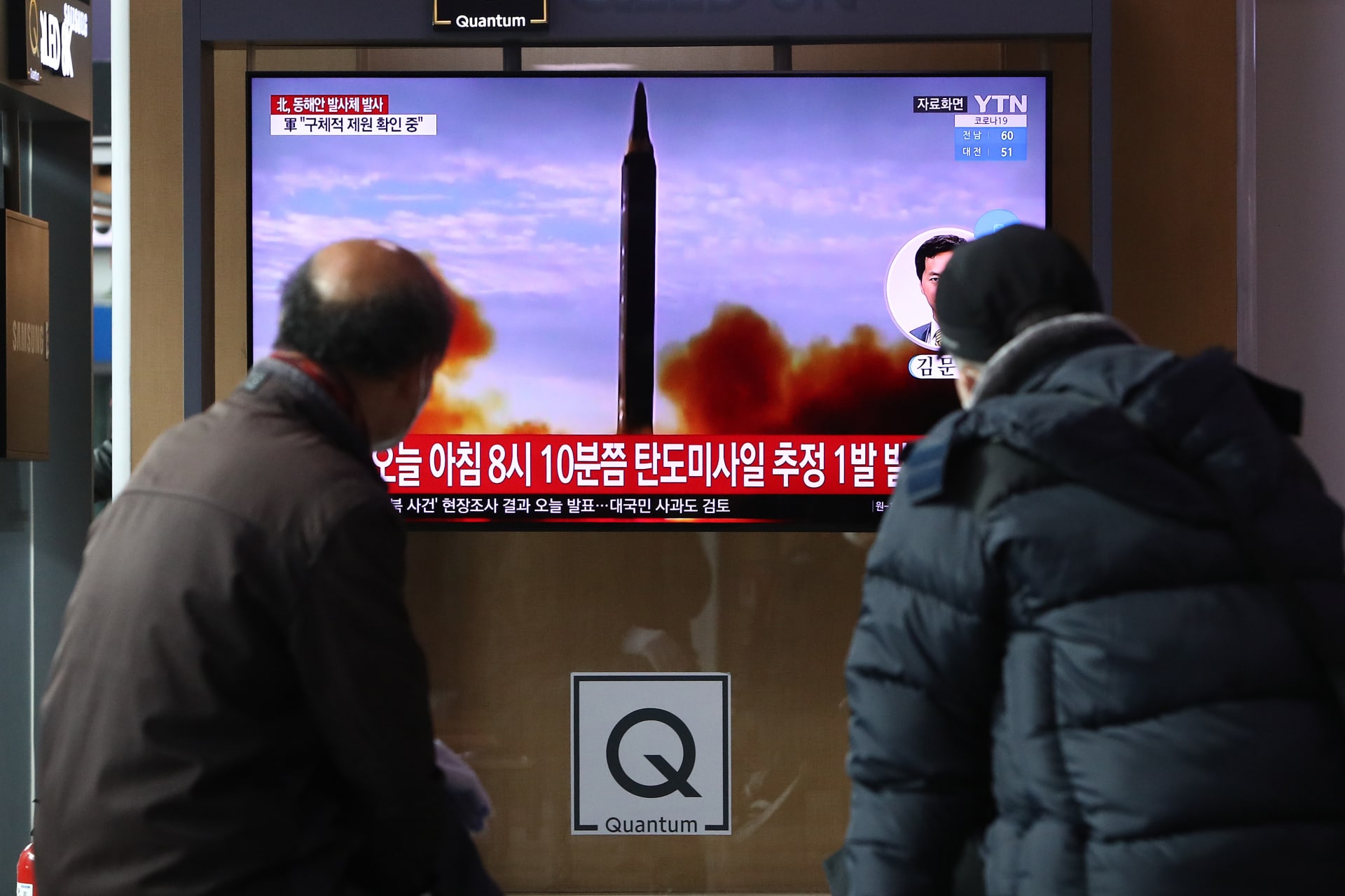 شخصان يشاهدان تلفزيونا في محطة سكة حديد سيول يعرض صورة لصاروخ أطلقته كوريا الشمالية في 5 يناير 2022