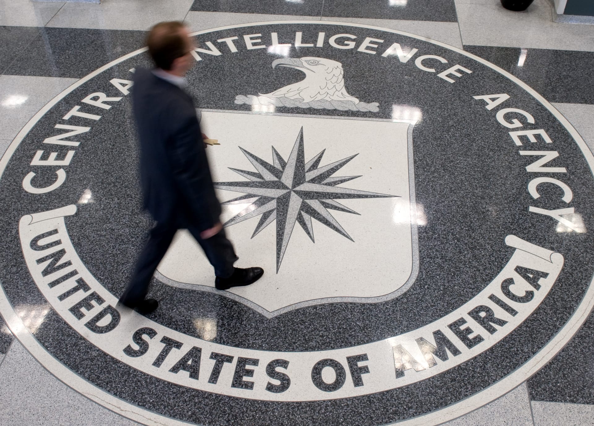 رجل يمشى على شعار وكالة الاستخبارات الأمريكية في مقرها بولاية فيرجينيا
