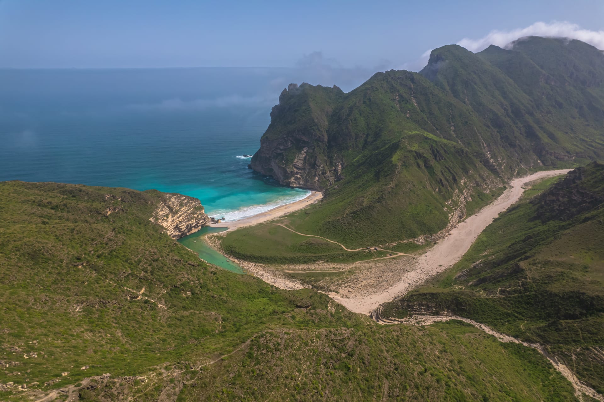 ليست جزر هاواي.. مشهد لجبال خضراء تعانق مياه البحر في سلطنة عمان يثير الحيرة