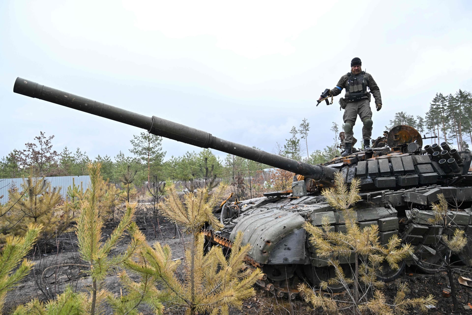جندي أوكراني يقف على دبابة روسية مدمرة 