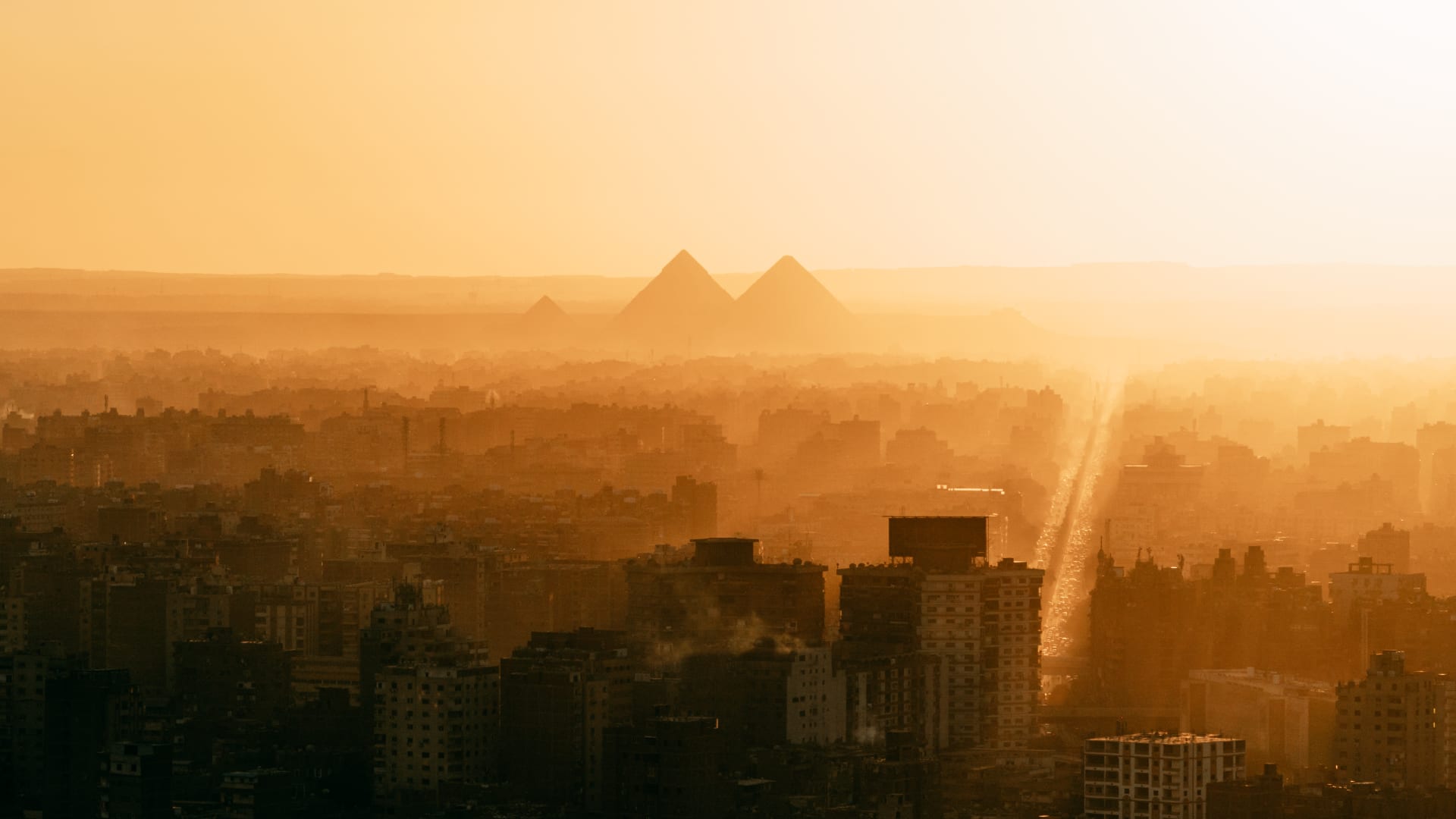 مشهد "خيالي" لأهرامات الجيزة وقت الغروب..كيف وثقه مصري من على سطح مبنى بالقاهرة؟