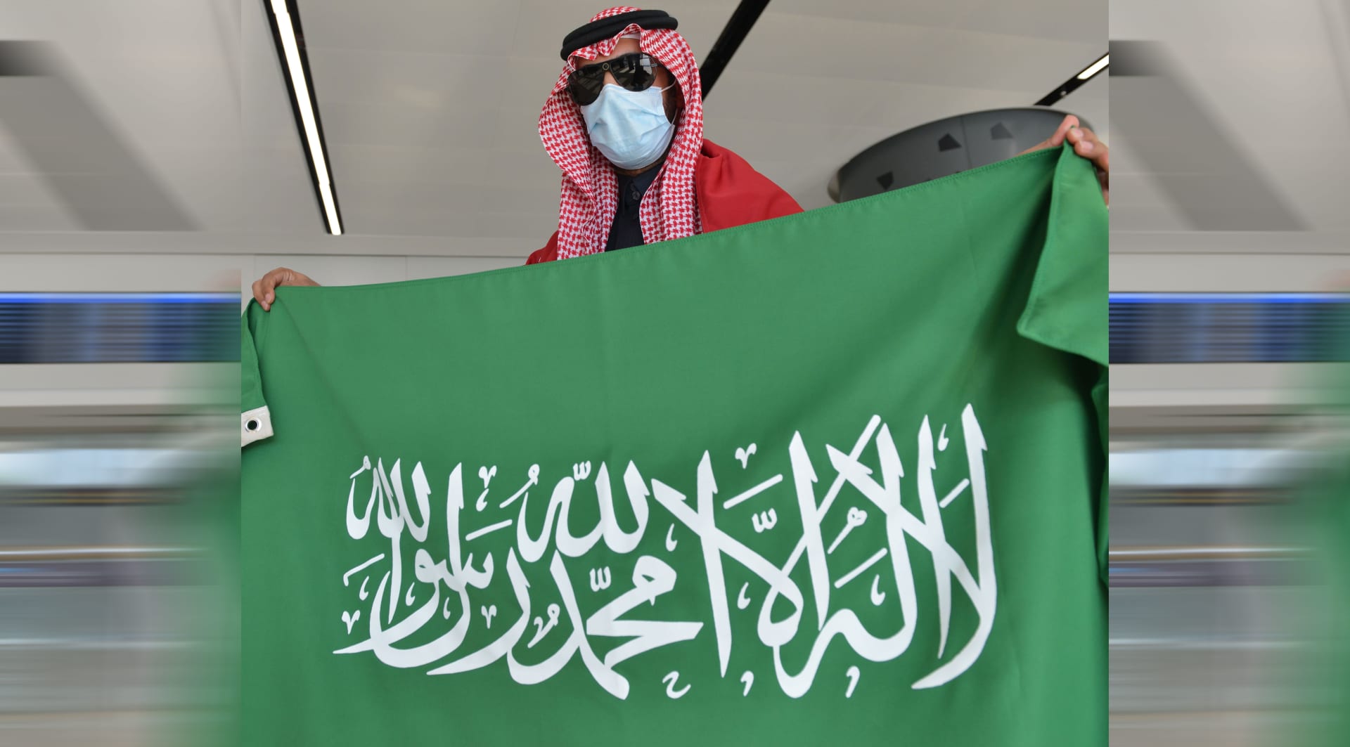 صورة أرشيفية تعبيرية لرجل يرفع العلم السعودي 