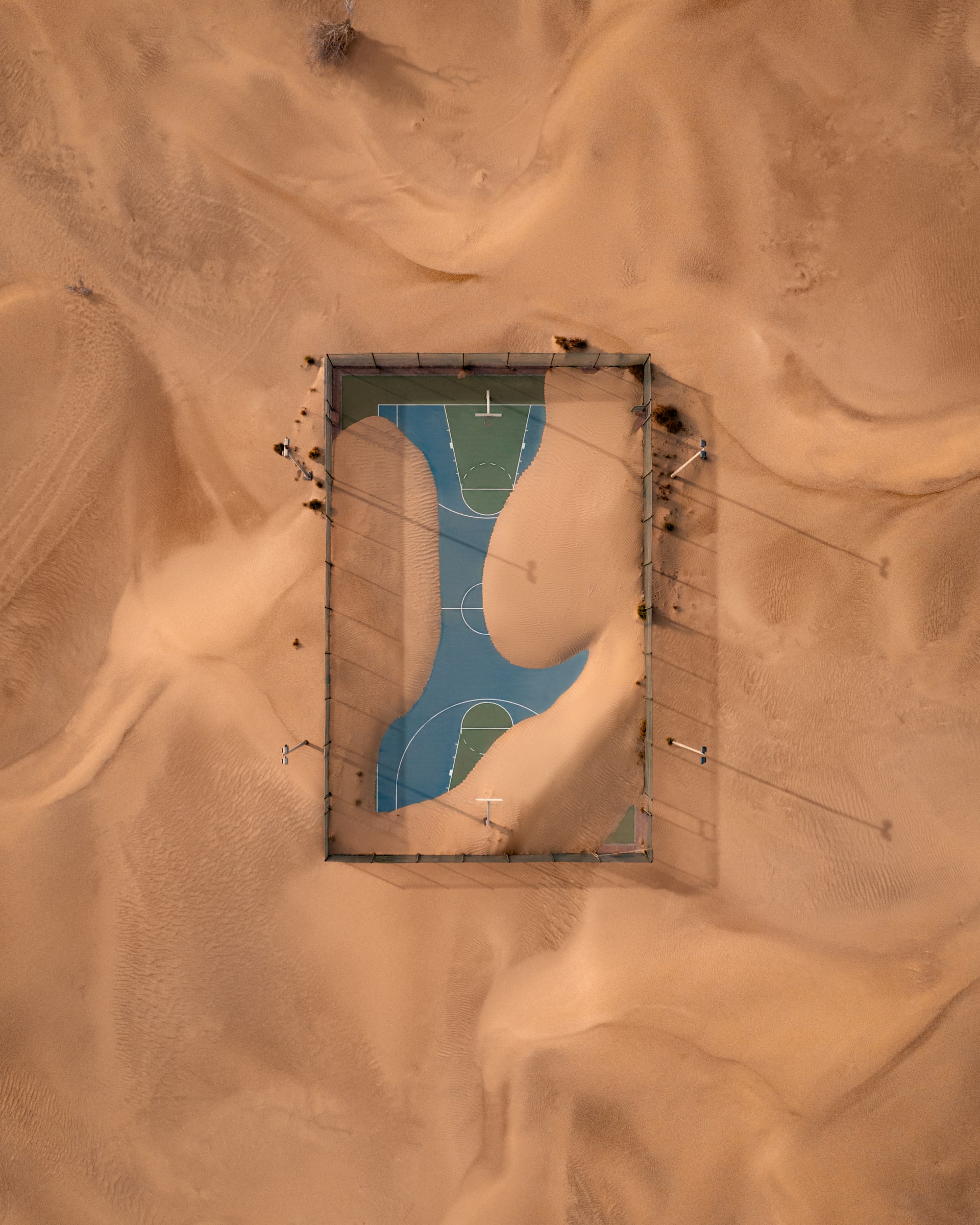من زاوية فريدة.. مصور يوثق ملعب كرة سلة ابتلعه الرمال في الإمارات