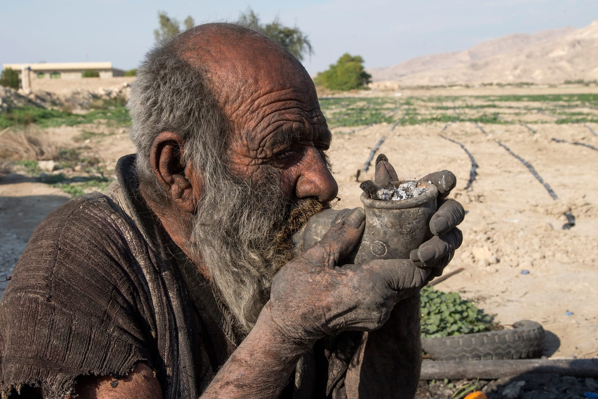 صورة أرشيفية لـ "عمو حاجي" يدخن في قريته بمحافظة فارس جنوب غرب إيران، في 28 ديسمبر 2018