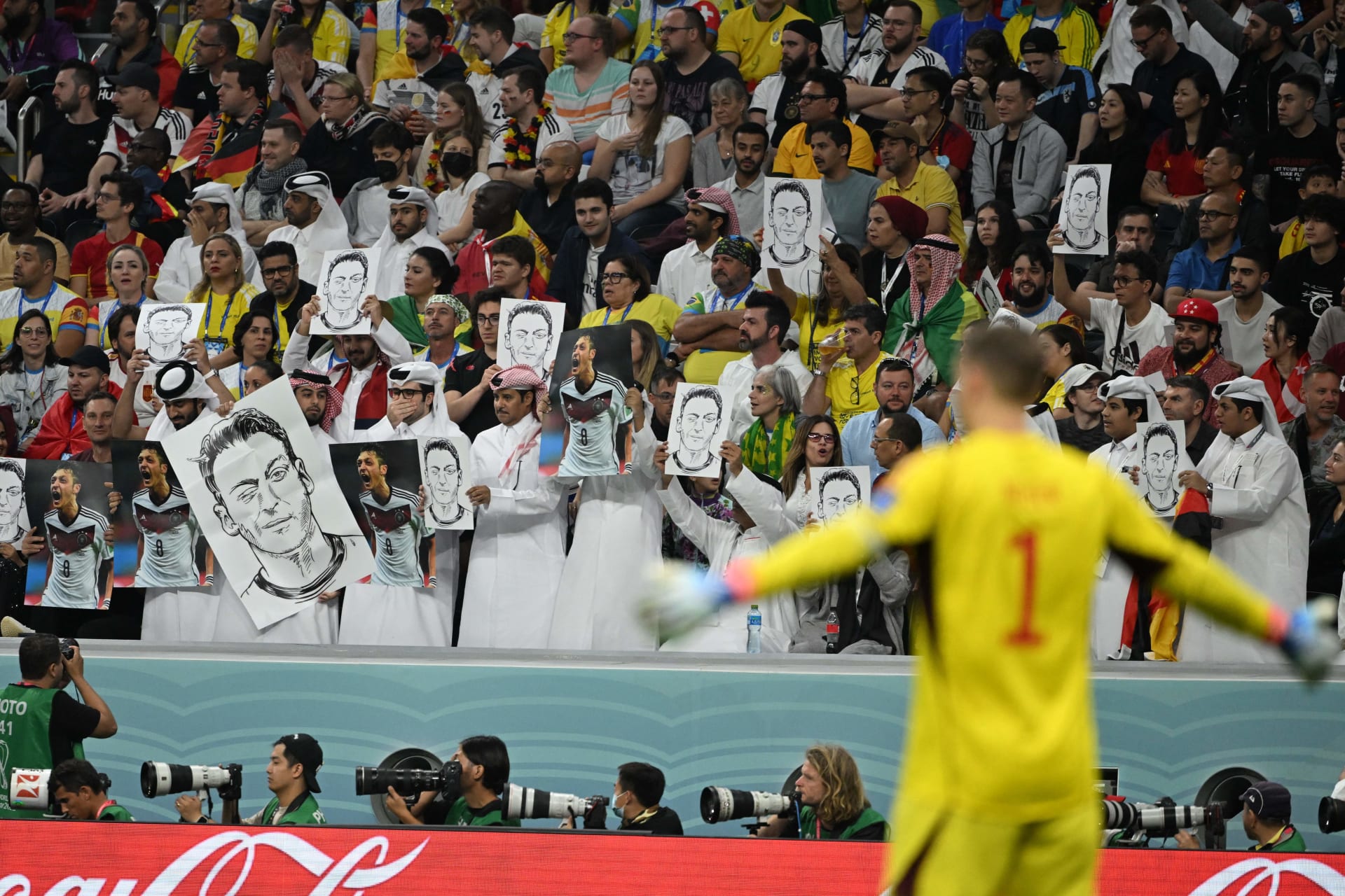 مشجعون يحملون صورة مسعود أوزيل ويغلقون أفواههم