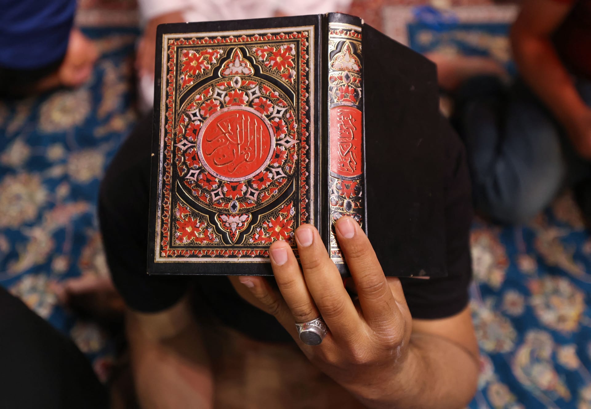 صورة تعبيرية لرجل يحمل نسخة من القرآن 