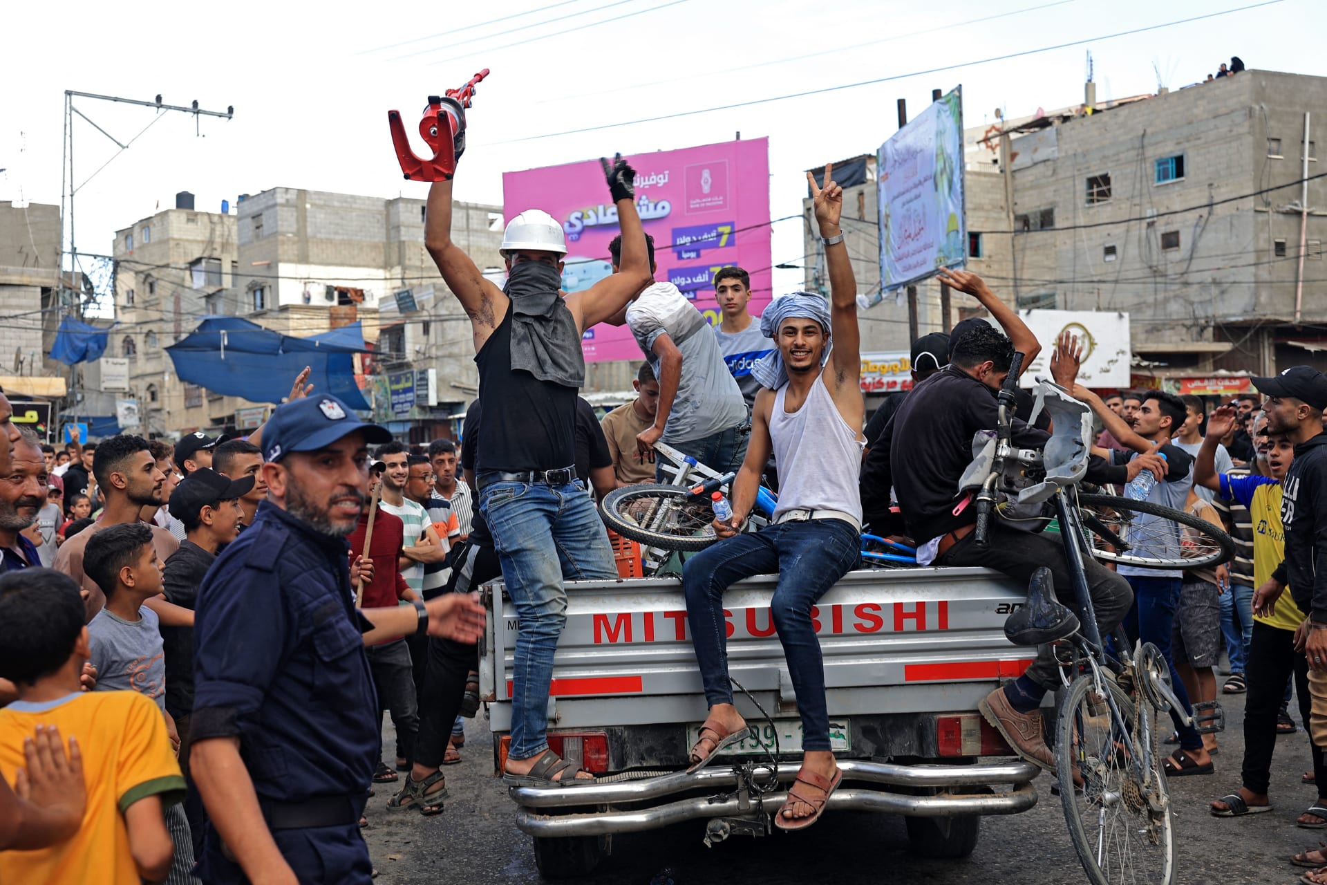 فلسطينيون يحتفلون بعودتهم بعد عبور السياج الحدودي مع إسرائيل من خان يونس جنوب قطاع غزة في 7 أكتوبر 2023