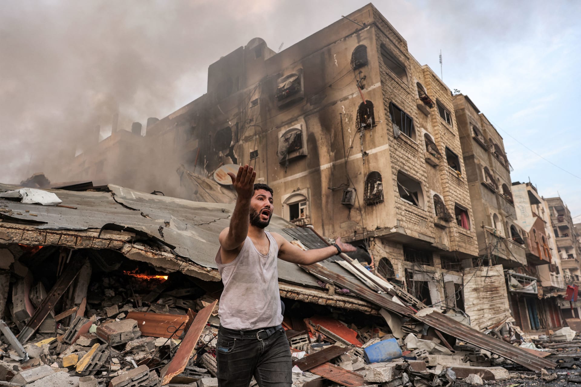 رجل خارج مبنى محترق منهار بعد القصف الإسرائيلي في مدينة غزة في 11 أكتوبر 2023