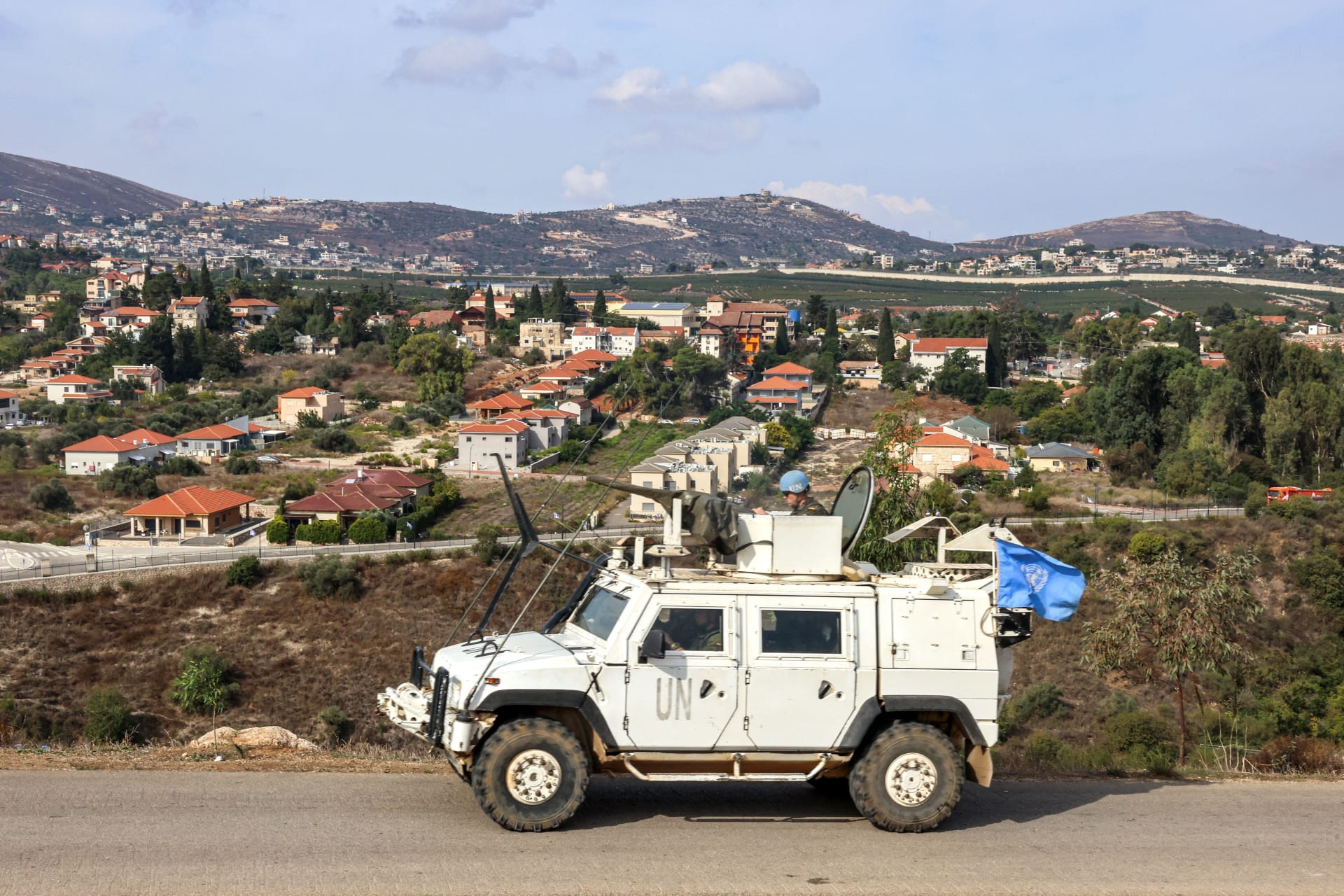 مركبة مدرعة تابعة لقوات الأمم المتحدة المؤقتة في لبنان (اليونيفيل) تتمركز بالقرب من نقطة حدودية في سهل الخيام اللبناني، مقابل بلدة المطلة شمال إسرائيل (الخلفية) في 11 أكتوبر/ تشرين الأول 2023.