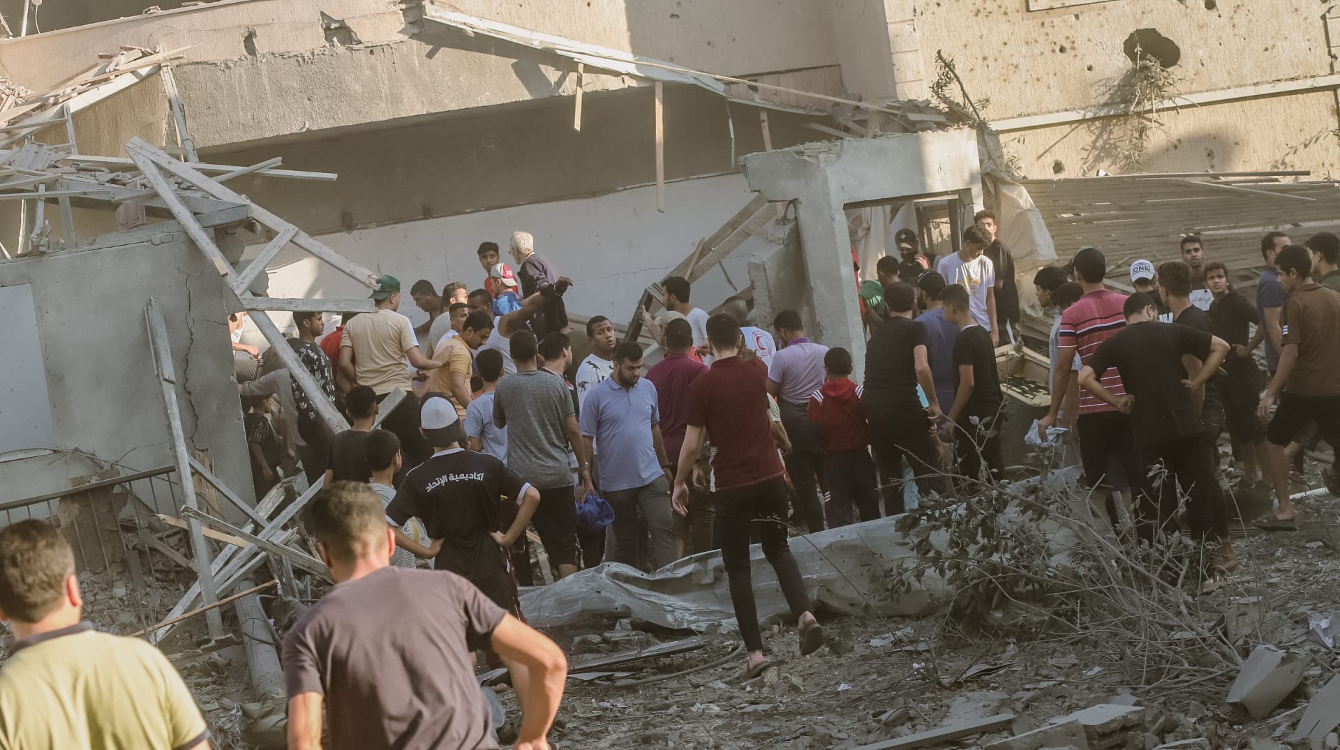 فريق إنقاذ وسكان يعملون  معًا لانتشال جثة من تحت أنقاض مبنى دمرته الغارات الجوية الإسرائيلية