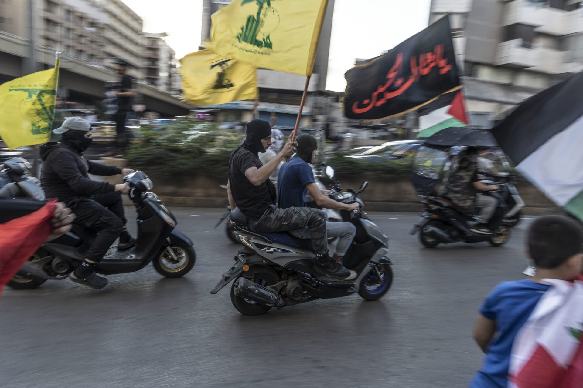 شبان لبنانيون من أنصار حزب الله يركبون الدراجات ويلوحون بأعلام الحزب بمسيرة لدعم الفلسطينيين في 20 أكتوبر 2023 في بيروت، لبنان