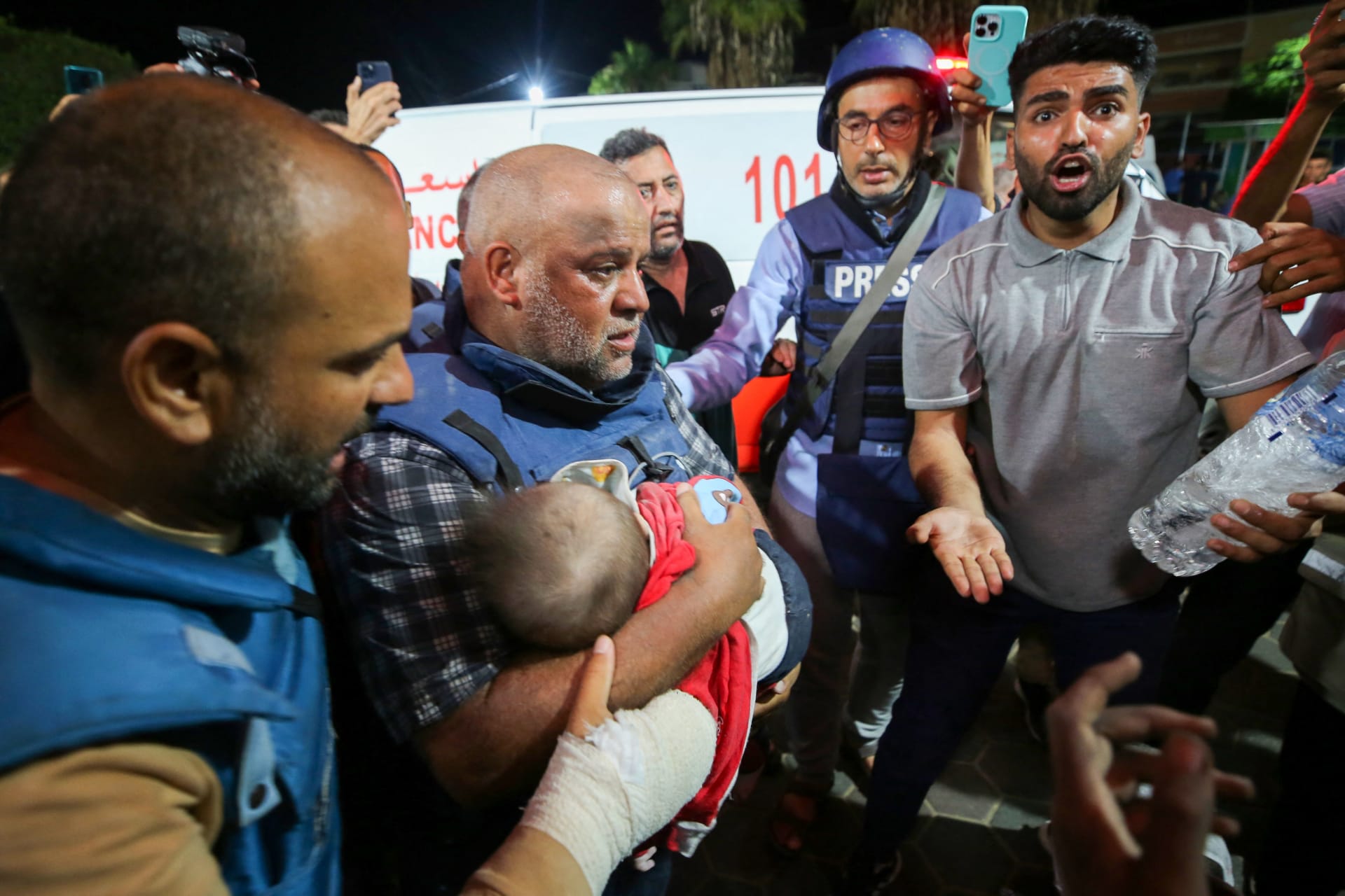 مراسل الجزيرة وائل الدحدوح يحمل جثة أحد أبنائه الاثنين اللذين قُتلوا مع زوجته في غارة إسرائيلية على مخيم النصيرات، في مستشفى الأقصى بدير البلح في جنوب قطاع غزة، في 25 تشرين الأول/أكتوبر 2023.